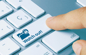 Finger hovering over a keyboard but the right hand tab key has been replaced with a button that says 'Watch Out!"